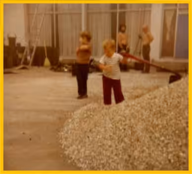 Historic photo of the Murphy children in the Murphy & Sons Roofing warehouse with roofing gravel