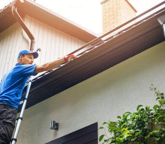 Kansas City gutter company Murphy & Sons – technician working on seamless gutters from a ladder Kansas City gutter company Murphy & Sons – technician working on seamless gutters from a ladder